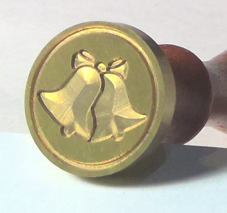 Round brass stamp with bell design on a white background