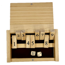 Miniature wooden Shut the Box game with numbered blocks and two dice on a white background