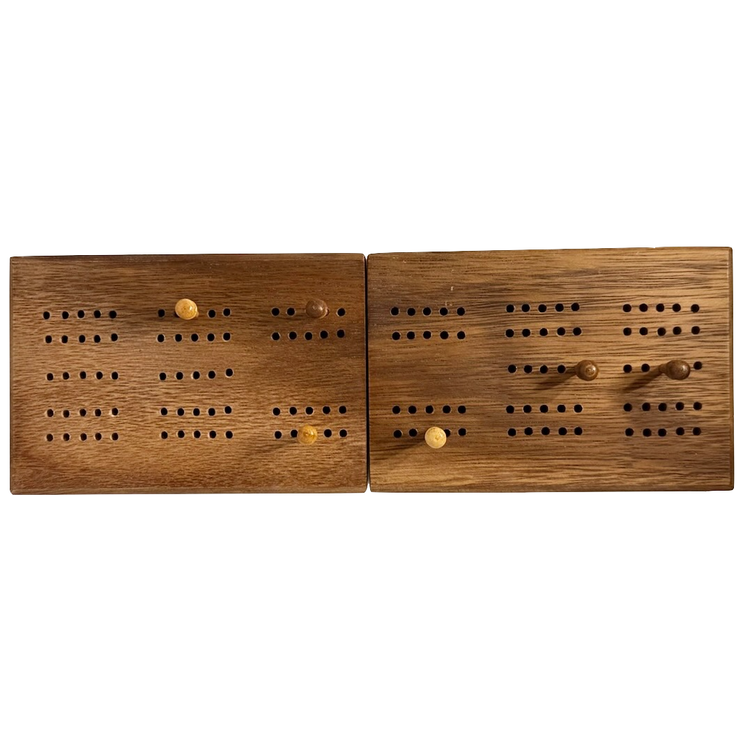 Pair of wooden cribbage boards with pegs on a white background