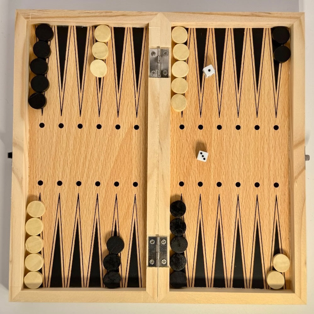Wooden backgammon board with pieces and dice on a plain background