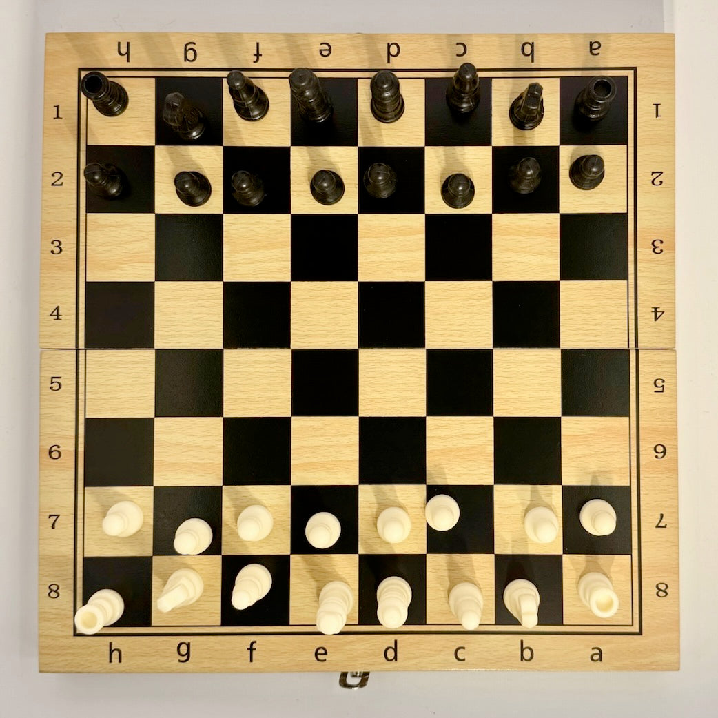 Wooden chessboard with pieces set up for a game