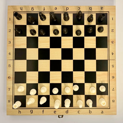 Wooden chessboard with pieces set up for a game