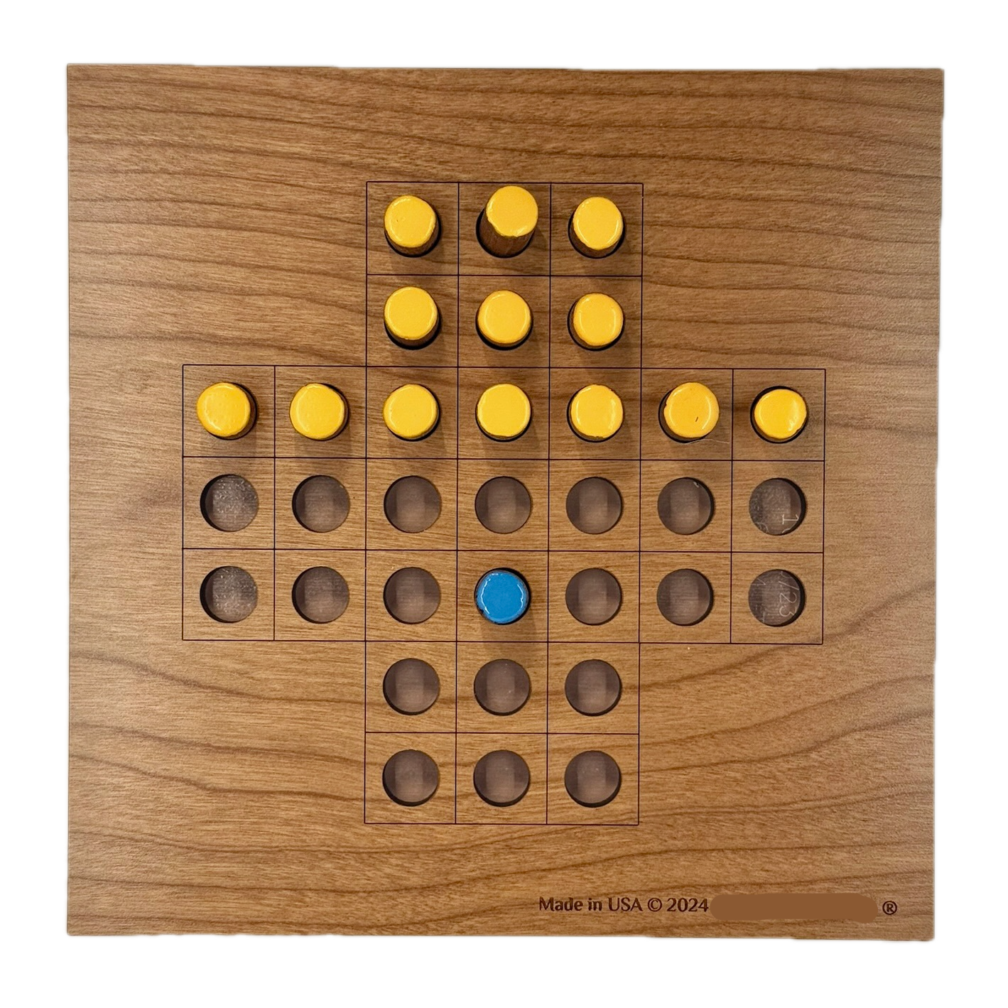 Wooden Solitaire game board with yellow and blue pieces 