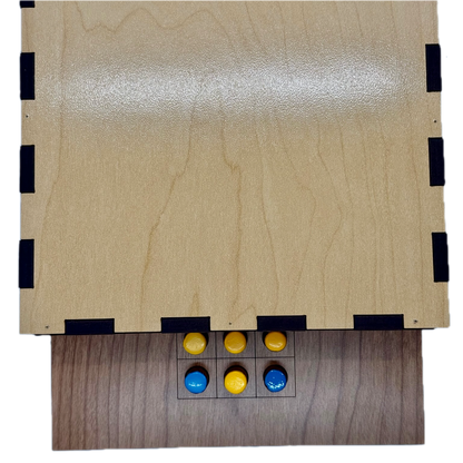 Back of wooden Solitaire game board with yellow and blue pieces 