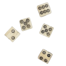 Five bone dice with circular patterns on a white background