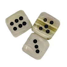 Three onyx dice with black markings on a white background