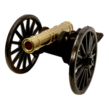 Brass replica Trail Cannon toy on a white background