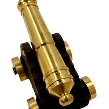 Close-up of a brass replica ship cannon on a white background