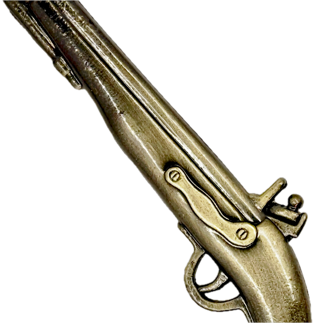 Close-up of a replica pewter cast pistol toy on a white background