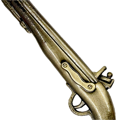 Close-up of a replica pewter cast pistol toy on a white background