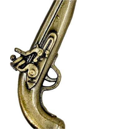 Close-up of a replica pewter cast pistol toy on a white background