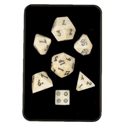 Set of polyhedral bone dice with white faces and black numbers in a black box