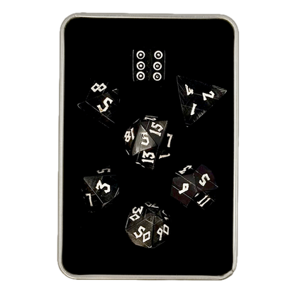 Black polyhedral horn dice set in a box on a white background