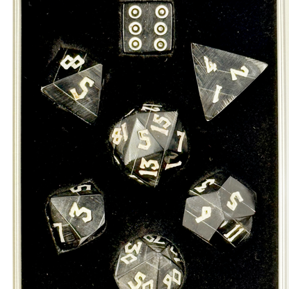 Set of polyhedral black horn dice with white numbers in a black box