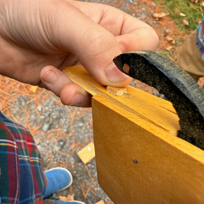 Child playing with a wooden Snake in the Box toy outdoors