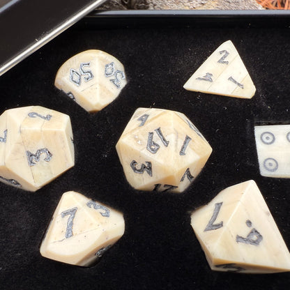 Set of polyhedral bone dice with black numbering in a black box