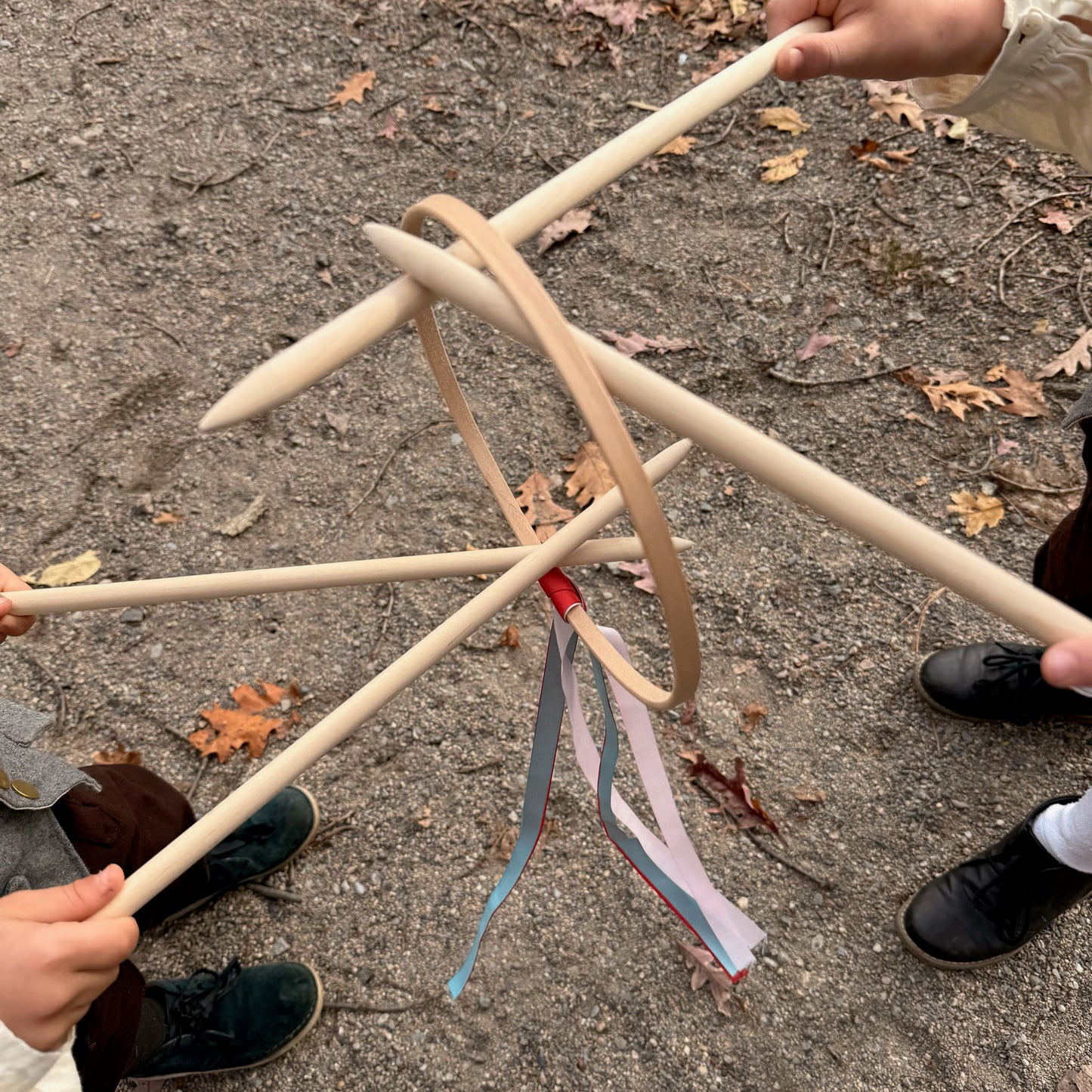 Children holding a Graces game on a rocky surface.