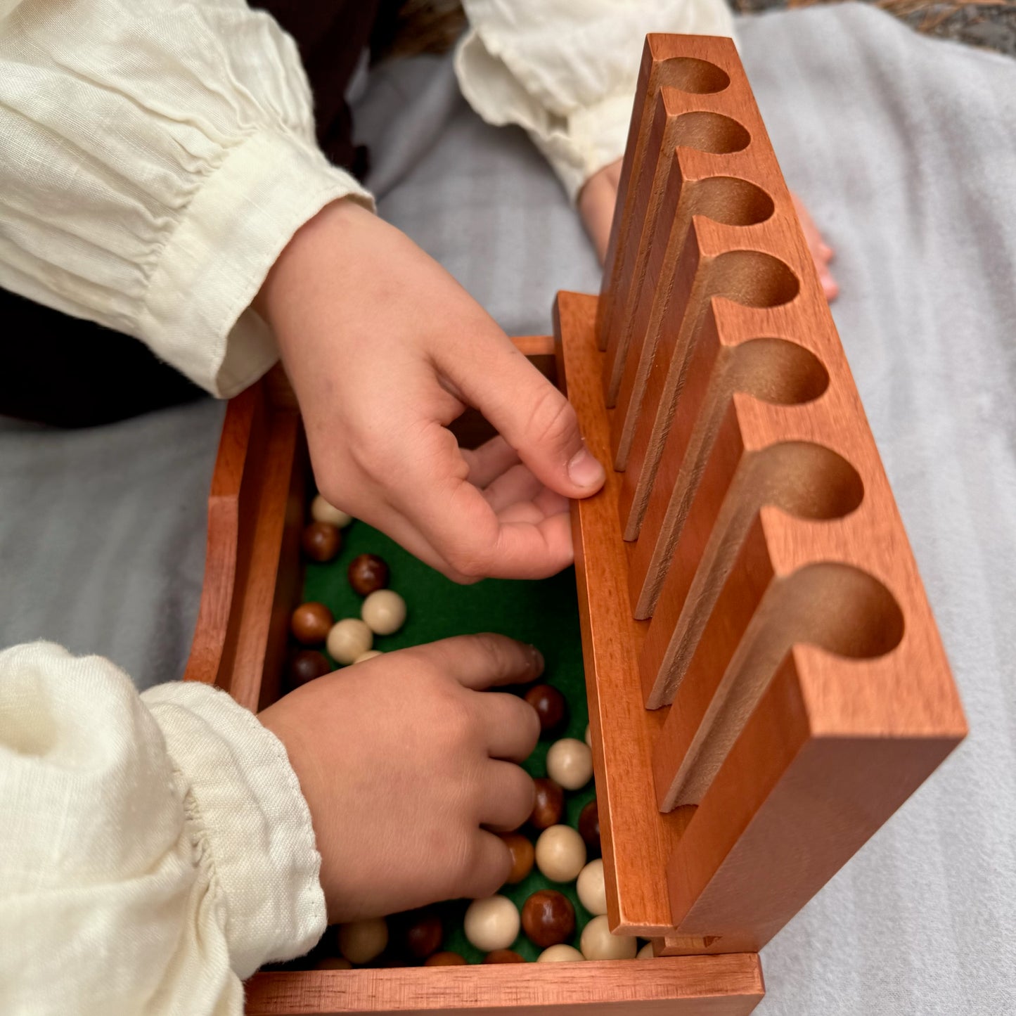 Children playing with a wooden Captain's Mistress game