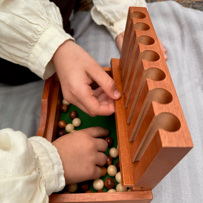 Children playing with a wooden Captain's Mistress game