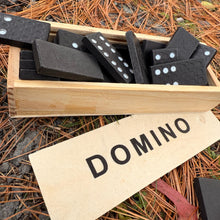 Set of dominoes in a wooden box with 'DOMINO' label on a natural background