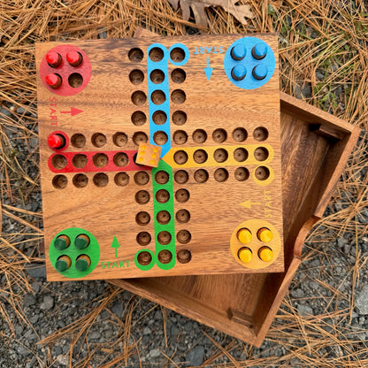 Wooden Ludo game board with colorful pegs on a natural background
