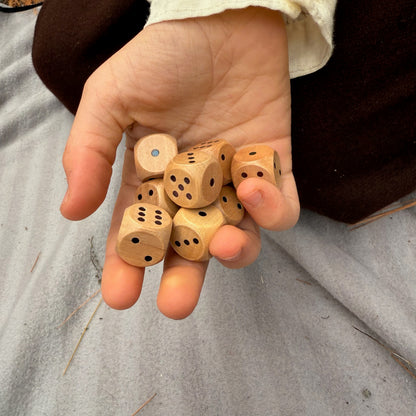 Hand holding wooden dice on a neutral background