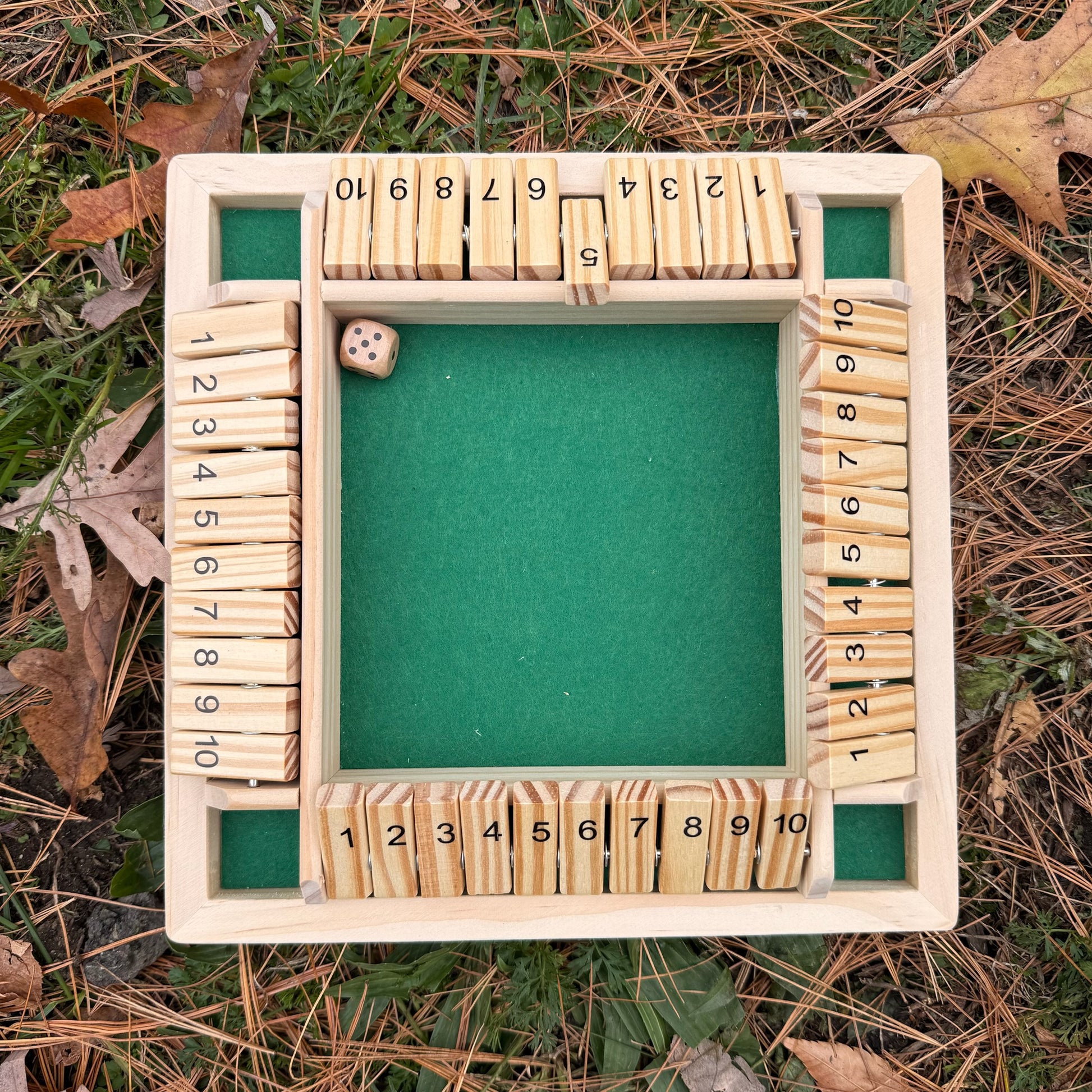Wooden Shut the Box game on a grassy background