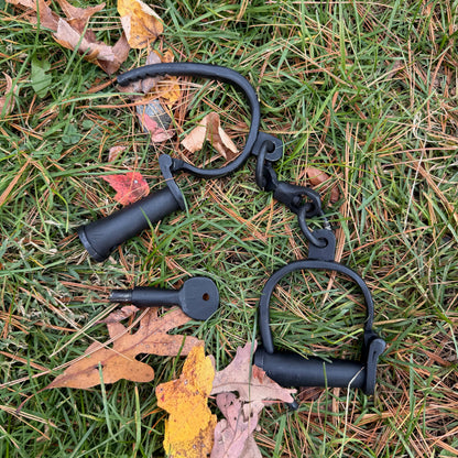 Black iron shackles on grass with fallen leaves