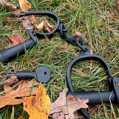 Black iron shackles on grass with leaves