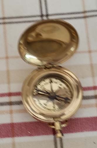 Gold pocket watch on a plaid fabric background