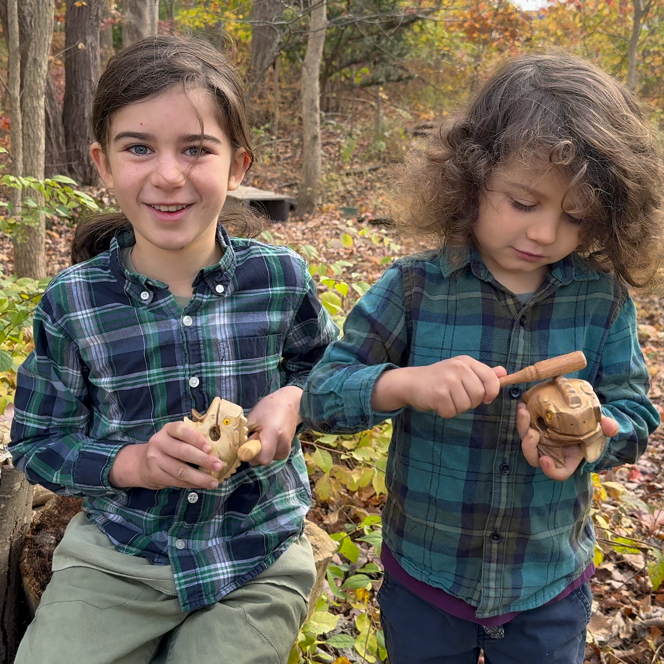 Two children in plaid shirts playing with Croaky Frog toys